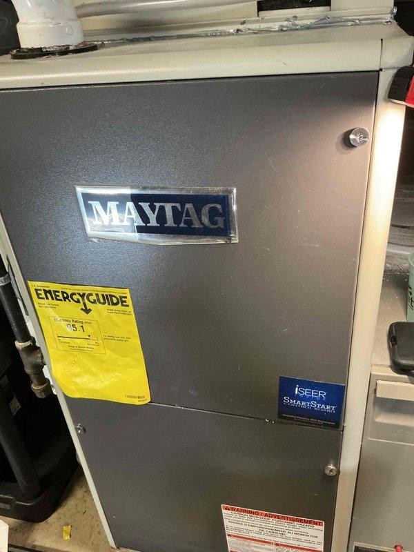 Responded to service call for leaking A/C condenser pan on Maytag variable speed air handler unit. Upon arrival, performed diagnostic inspection and documented equipment information including model specifications and SEER rating. Unit was photographed for service records showing overall condition and identifying labels.