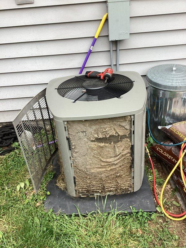 # HVAC Service Completed

Responded to no-cooling complaint on residential split system air conditioning unit. Upon arrival, performed initial visual inspection of outdoor condenser unit and found front access panel accessible for diagnostic evaluation.

Removed front service panel to inspect internal components and discovered heavily soiled condenser coils with substantial accumulation of dirt, dust, and debris throughout the unit interior. The buildup was severe enough to significantly restrict airflow through the coil fins, which would prevent proper heat exchange and cause the system to fail to cool effectively or cycle off on safety controls.

The extensive contamination of the condenser coils was identified as the primary cause of the no-cooling condition. Dirty coils reduce system efficiency, increase head pressure, and can cause the compressor to overheat and shut down on thermal overload protection, preventing the unit from operating normally.

Prepared unit for coil cleaning 