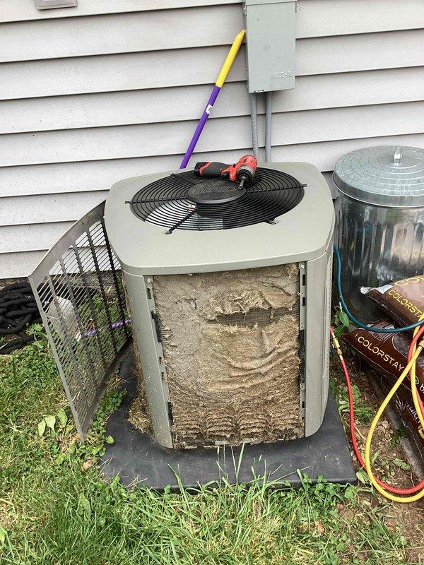 # HVAC Service Completed

Responded to no-cooling complaint on residential split system air conditioning unit. Upon arrival, performed initial visual inspection of outdoor condenser unit and found front access panel accessible for diagnostic evaluation.

Removed front service panel to inspect internal components and discovered heavily soiled condenser coils with substantial accumulation of dirt, dust, and debris throughout the unit interior. The buildup was severe enough to significantly restrict airflow through the coil fins, which would prevent proper heat exchange and cause the system to fail to cool effectively or cycle off on safety controls.

The extensive contamination of the condenser coils was identified as the primary cause of the no-cooling condition. Dirty coils reduce system efficiency, increase head pressure, and can cause the compressor to overheat and shut down on thermal overload protection, preventing the unit from operating normally.

Prepared unit for coil cleaning 