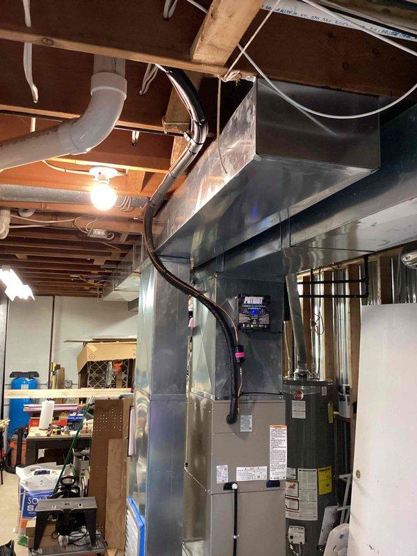 Completed installation of Infinity brand air conditioning system with matching evaporator coil in residential basement location. New AC unit and coil were properly positioned, connected to existing ductwork via galvanized metal plenum, and integrated with condensate drainage system using white PVC piping. All electrical connections, refrigerant lines, and ductwork transitions were secured and tested to ensure proper system operation and compliance with manufacturer specifications.