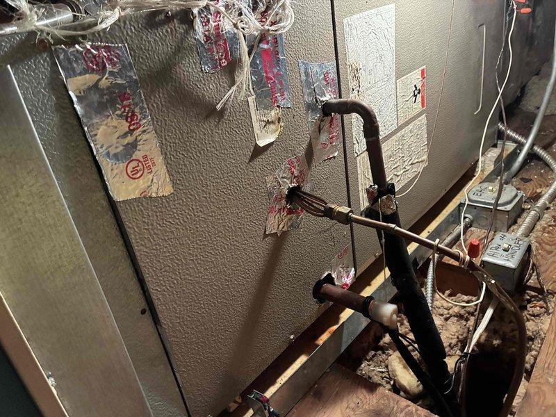 Completed air conditioning tune-up service on attic-mounted air handler unit. Performed standard maintenance inspection of equipment, refrigerant lines, and electrical connections. Documented existing pipe penetration through exterior wall showing signs of corrosion requiring future attention.