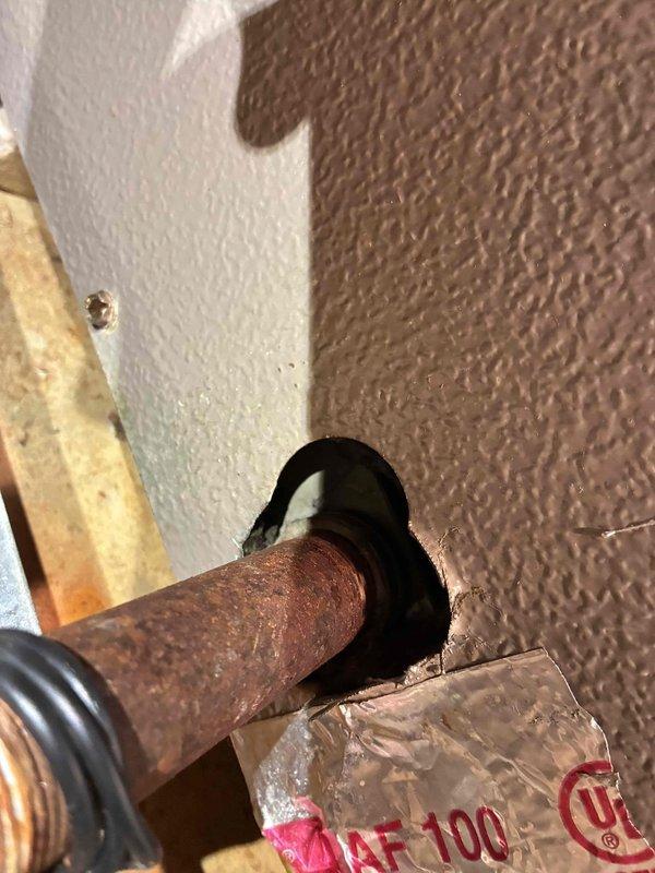 Completed air conditioning tune-up service on attic-mounted air handler unit. Performed standard maintenance inspection of equipment, refrigerant lines, and electrical connections. Documented existing pipe penetration through exterior wall showing signs of corrosion requiring future attention.
