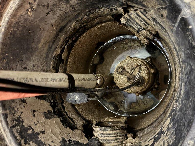 Conducted comprehensive site assessment of existing sump pump system located in basement utility area. Evaluated current pump installation, discharge piping configuration, and basin condition to prepare estimate for complete sump pump replacement and battery backup system installation. Documented deteriorated basin conditions, corroded mechanical components, and aged discharge piping showing mineral buildup and significant wear. Identified need for new primary sump pump unit with enhanced capacity, installation of battery backup system to ensure continuous operation during power outages, and replacement of compromised mounting hardware and discharge assembly.