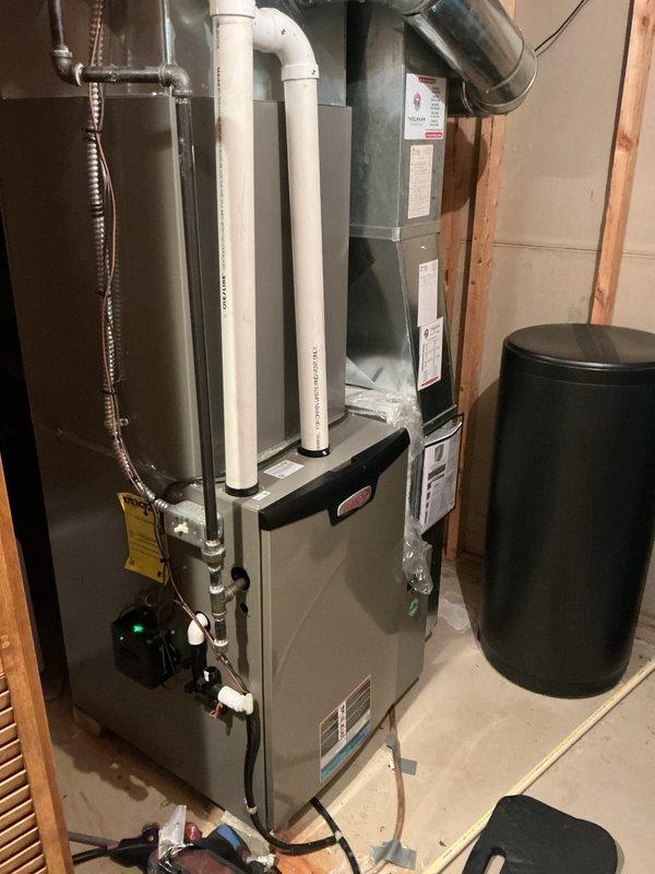 Completed furnace tune-up and air conditioning tune-up on residential HVAC system located in basement utility area. Performed comprehensive inspection and maintenance on gray cabinet furnace unit and air handler, including filter check, burner inspection, electrical connection verification, condensate drain line evaluation, and refrigerant line assessment. All equipment found operating within normal parameters with no immediate service needs identified.
