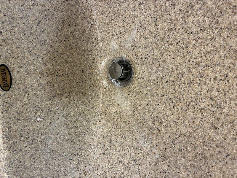 Reconnected bathroom sink drain assembly to pop-up stopper mechanism. The drain linkage had become detached, preventing proper stopper operation. Reattached pivot rod to stopper, tested functionality, and verified proper drainage and seal.