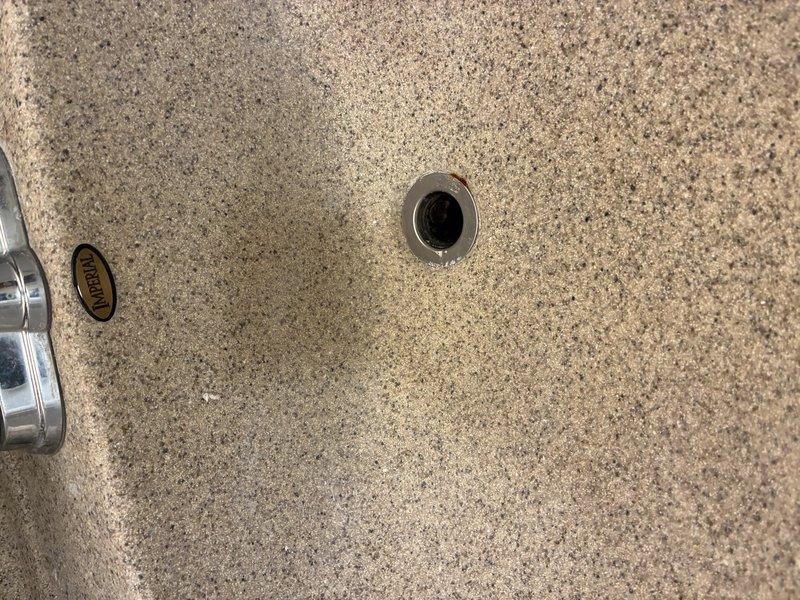 Reconnected bathroom sink drain assembly to pop-up stopper mechanism. The drain linkage had become detached, preventing proper stopper operation. Reattached pivot rod to stopper, tested functionality, and verified proper drainage and seal.