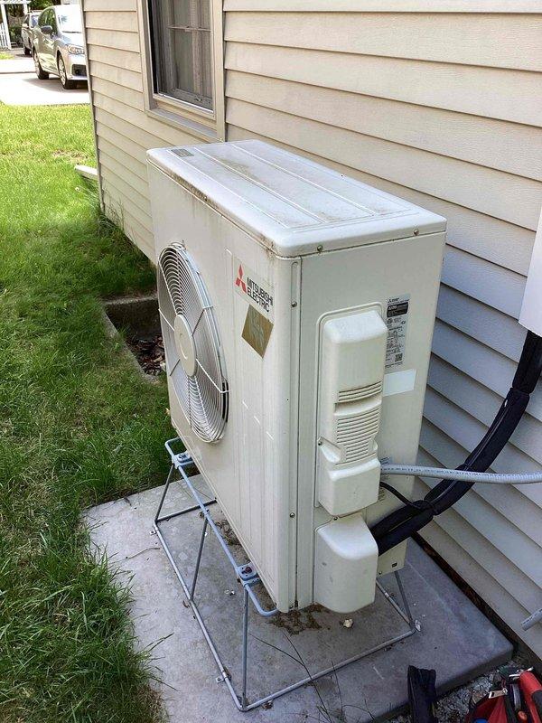 Responded to service call for Mitsubishi Electric mini-split heat pump system not cooling upstairs zone. Upon arrival, performed diagnostic inspection of outdoor condenser unit and indoor air handler. Verified system installation date and confirmed active warranty coverage for parts and labor. Conducted visual inspection of outdoor unit, checking refrigerant line connections, condenser coil condition, and overall equipment operation. Documented equipment condition with photographs showing proper installation on concrete pad with appropriate clearances. System evaluated for performance issues affecting cooling capacity in upper level zone.