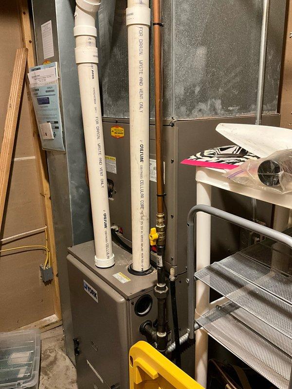 Completed estimate for complete HVAC system replacement at residential property. Assessed existing natural gas furnace located in basement mechanical room with associated PVC venting and copper gas line with shutoff valve. Evaluated non-operational York brand air conditioning condenser unit positioned on concrete pad with gravel base against exterior wall. Provided replacement recommendations for both heating and cooling equipment to restore full system functionality.