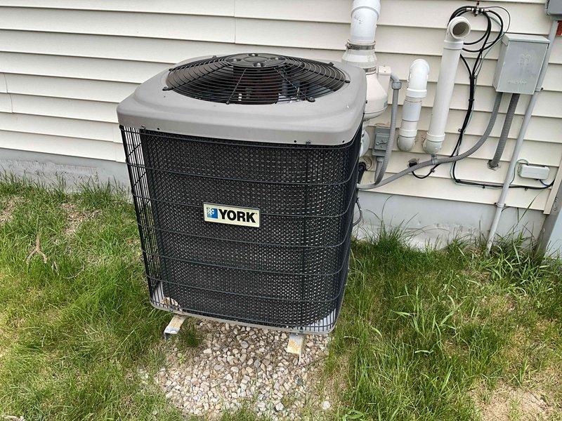Completed estimate for complete HVAC system replacement at residential property. Assessed existing natural gas furnace located in basement mechanical room with associated PVC venting and copper gas line with shutoff valve. Evaluated non-operational York brand air conditioning condenser unit positioned on concrete pad with gravel base against exterior wall. Provided replacement recommendations for both heating and cooling equipment to restore full system functionality.