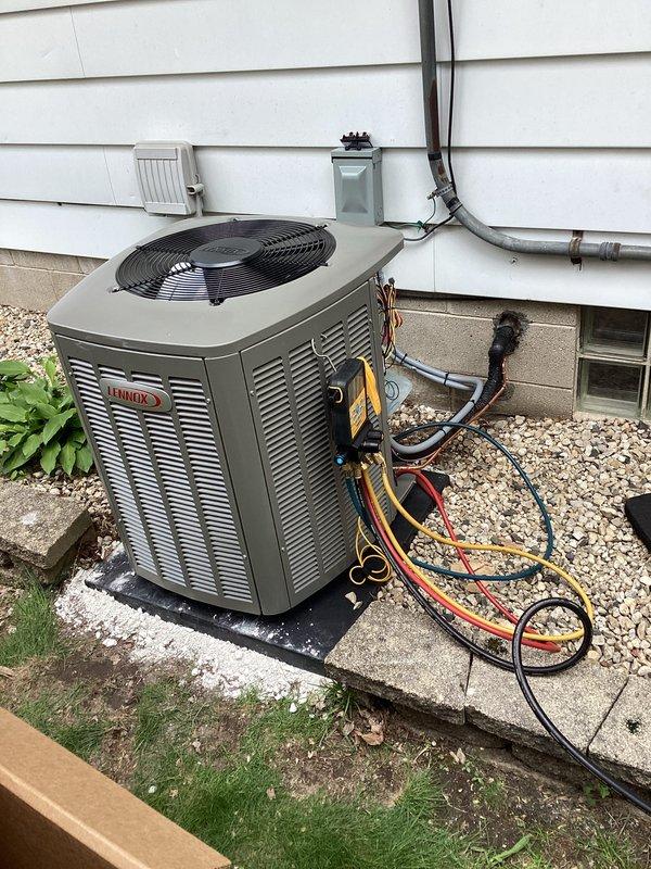 Completed installation of Lennox air handler system with 3-man crew at residential garage location (code 6076). Unit was properly positioned on concrete pad with gravel base, refrigerant lines and electrical conduit secured to exterior wall, and system charged and tested to manufacturer specifications.