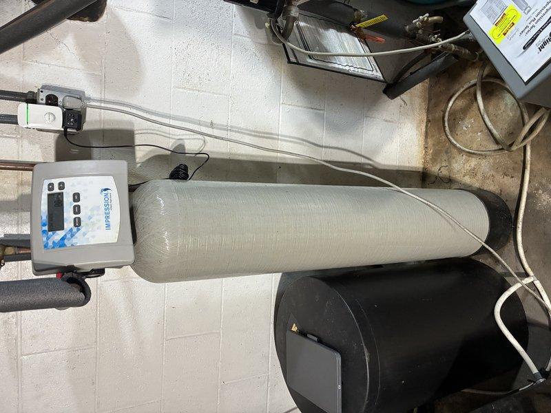 Completed on-site estimate for replacement of existing iron curtain water treatment system. Inspected current installation including control valve assembly with electronic controller, insulated media tank, and associated plumbing connections. Documented equipment condition and provided replacement recommendations for upgraded water treatment solution to address iron removal needs.