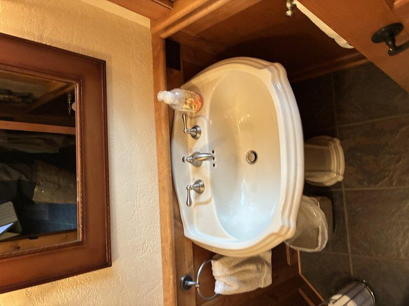 Completed comprehensive plumbing inspection of residential property to assess multiple fixture issues. Inspected leaking faucet at pedestal sink with chrome cross-handle fixtures, evaluated broken exterior hose bib, and assessed six existing toilets for replacement with comfort-height almond-colored units. Documented current conditions of plumbing fixtures and pipe insulation in utility areas, noting valve assemblies and existing infrastructure to provide accurate replacement estimates.