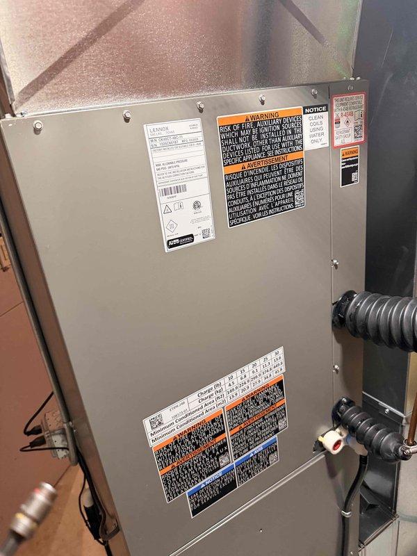 Completed installation call back for replacement evaporator coil on Lennox air handler unit. Verified proper coil installation, confirmed secure mounting within the unit cabinet, and inspected all refrigerant line connections. Documented installed coil assembly with internal insulation intact and evaporator positioned correctly in lower housing. All manufacturer labels, safety warnings, and specifications visible and properly affixed to unit exterior. System ready for operation.
