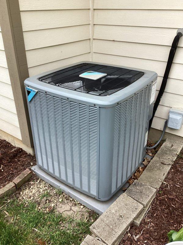 Responded to no cooling complaint on residential split system air conditioning unit. Upon arrival, found outdoor condenser unit running with fan motor operational but system not producing cold air. Performed diagnostic inspection of condenser components through top access panel, verified fan motor operation and checked for proper compressor function. Unit remains under parts and labor warranty coverage.