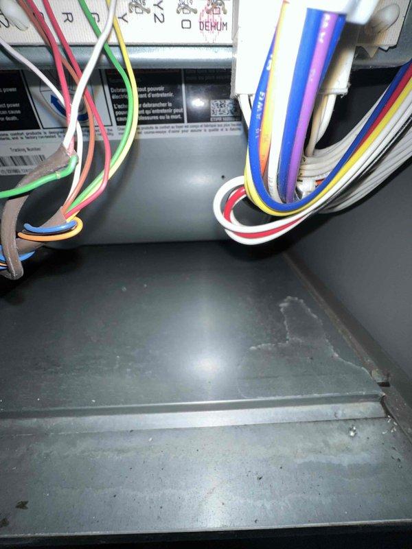 Responded to service call for upstairs HVAC unit inspection due to water heater leaking in proximity to equipment. Performed comprehensive inspection of air handler system located in attic space to assess potential water damage from recurring water heater leak. Inspected control board, wiring connections, and electrical components for moisture intrusion and corrosion. Observed visible water staining and moisture marks on interior base pan of air handler unit. Examined blower motor assembly, drain lines, and PVC condensate piping for proper operation and potential secondary water damage. Documented equipment condition with photographs showing control wiring, dehumidification components, and overall air handler installation. Recommended homeowner contact insurance provider regarding water damage assessment and potential equipment replacement or remediation due to ongoing water exposure from external source.