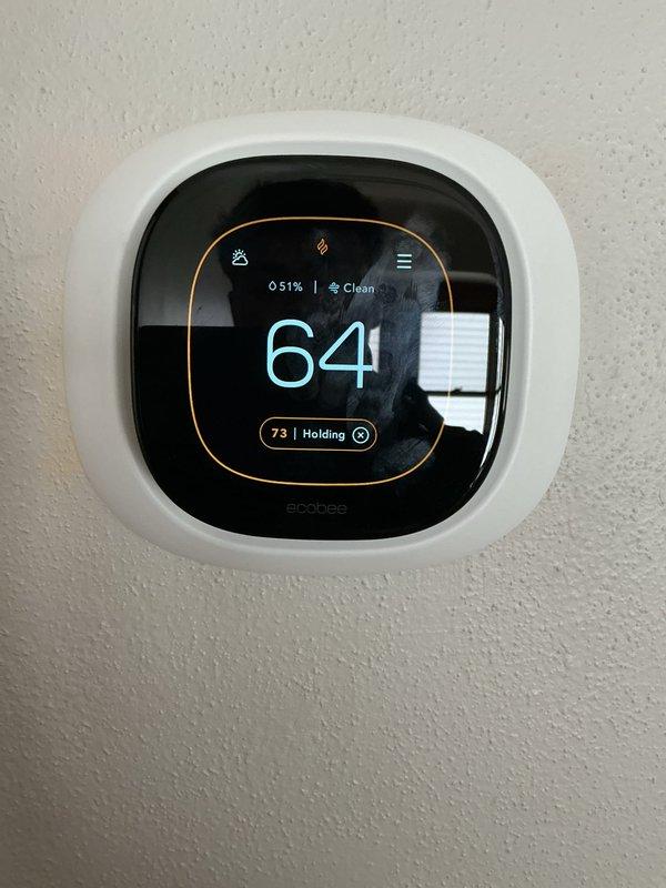 Responded to no heat call following third-party thermostat installation. Upon arrival, found newly installed Ecobee smart thermostat displaying 64°F actual temperature with setpoint holding at 73°F but system not calling for heat. Inspected furnace cabinet and verified all electrical connections at blower motor and control board were secure with proper wire terminations. Traced thermostat wiring from unit to wall location and confirmed compatibility between new smart thermostat and existing HVAC system wiring. Reconfigured thermostat settings to properly communicate with heating equipment, tested system operation through multiple heating cycles, and verified furnace ignition sequence and blower motor engagement. System now heating properly and maintaining programmed temperature setpoint.