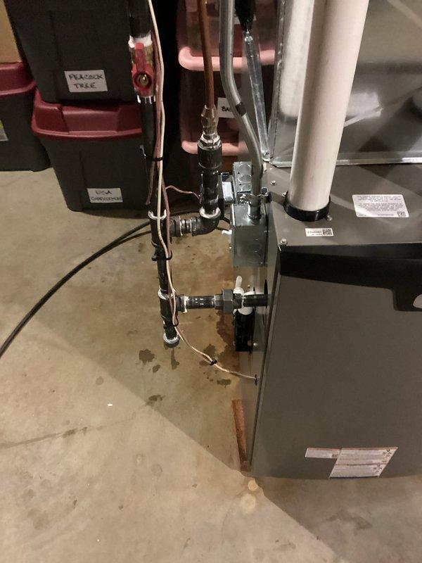 Completed full furnace and zoning system installation in basement utility area. Installed new air handler unit with copper refrigerant lines properly insulated and connected with appropriate fittings and valves. Ran PVC condensate drain line vertically from unit. Mounted all equipment securely to concrete floor with proper brackets and verified all plumbing connections meet code requirements. Installed zoning control components including electrical junction boxes and wiring harnesses on secondary unit. Routed black conduit lines along unit exterior and secured with mounting brackets. Connected all electrical components and verified proper operation of both heating unit and zoning controls. System tested and operational.