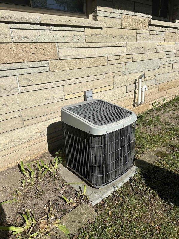 Conducted comprehensive evaluation of existing residential HVAC system for equipment replacement estimate. Assessed outdoor Lennox air conditioning condensing unit positioned on concrete pad against building exterior, noting current operational condition and installation configuration with refrigerant line sets penetrating through stone veneer wall. Inspected indoor components including furnace/air handler unit, plenum assembly, and ductwork transitions in basement utility area. Documented equipment specifications, system layout, and installation requirements. Photographed both outdoor condensing unit and indoor air handling components to support replacement proposal. Provided updated pricing and equipment options for complete system replacement.