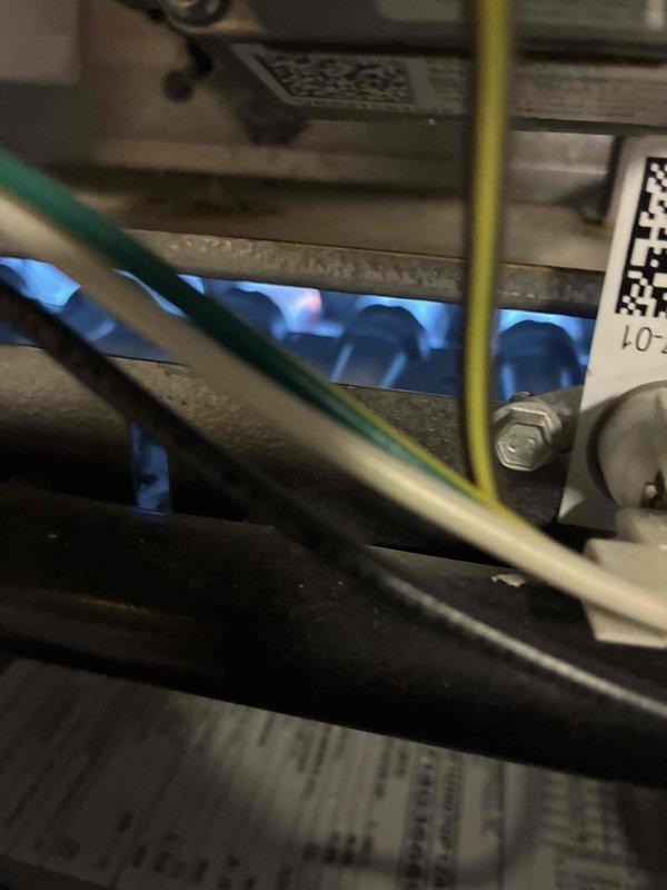 Completed furnace and air conditioning tune-up on residential HVAC system. Inspected burner assembly with active blue flames indicating proper combustion, verified gas connections and electrical wiring throughout unit, and examined outdoor condenser unit positioned against building exterior. All components operating within normal parameters with no immediate service needs identified.