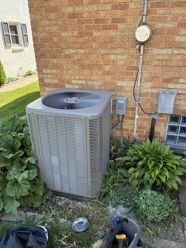 Completed furnace and air conditioning tune-up on residential HVAC system. Inspected burner assembly with active blue flames indicating proper combustion, verified gas connections and electrical wiring throughout unit, and examined outdoor condenser unit positioned against building exterior. All components operating within normal parameters with no immediate service needs identified.