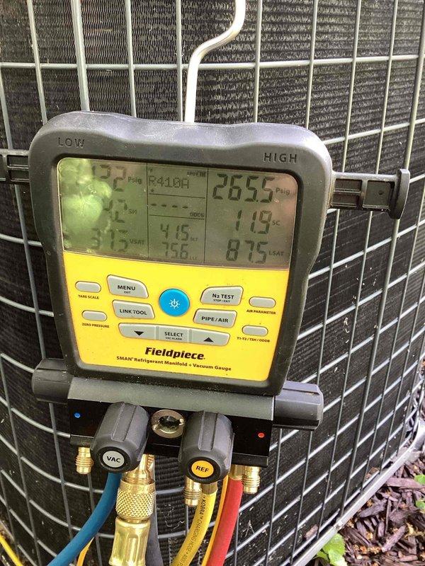 # HVAC Service Report

Responded to no cooling complaint on residential air conditioning system. Upon arrival, performed diagnostic testing of outdoor condensing unit using refrigerant manifold gauges and digital temperature measurement equipment. 

Diagnostic readings revealed abnormally high discharge temperature of 265.5°F and elevated system pressures, indicating potential compressor failure or severe refrigerant system restriction. High-side temperature of 119°F confirmed system operating outside normal parameters. Connected manifold gauge set to service ports and monitored system pressures during operation to verify compressor performance and refrigerant charge levels.

Documented equipment conditions with photographic evidence showing condenser unit installation and diagnostic tool readings for customer review. Recommend further evaluation to determine if compressor replacement or additional refrigerant system repairs are required to restore proper cooling operation.
