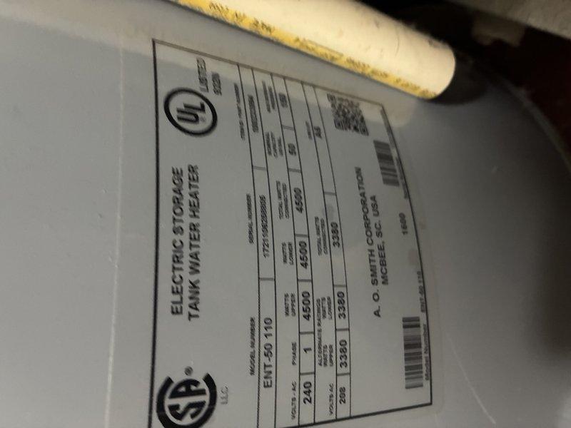 Responded to service call regarding rusty water observed beneath water heater. Upon arrival, performed comprehensive diagnostic inspection of A.O. Smith electric storage tank water heater (Model ENT-50, 50-gallon capacity, 4500-watt, 240-volt unit). Thoroughly examined tank exterior, all plumbing connections, copper and PVC piping, brass fittings, shut-off valves, and pressure relief valve for signs of active leakage or corrosion. Inspected floor area surrounding base of unit for moisture accumulation and traced potential sources of discoloration. Documented equipment condition and connection integrity with photographic evidence showing current installation configuration and manufacturer specifications.