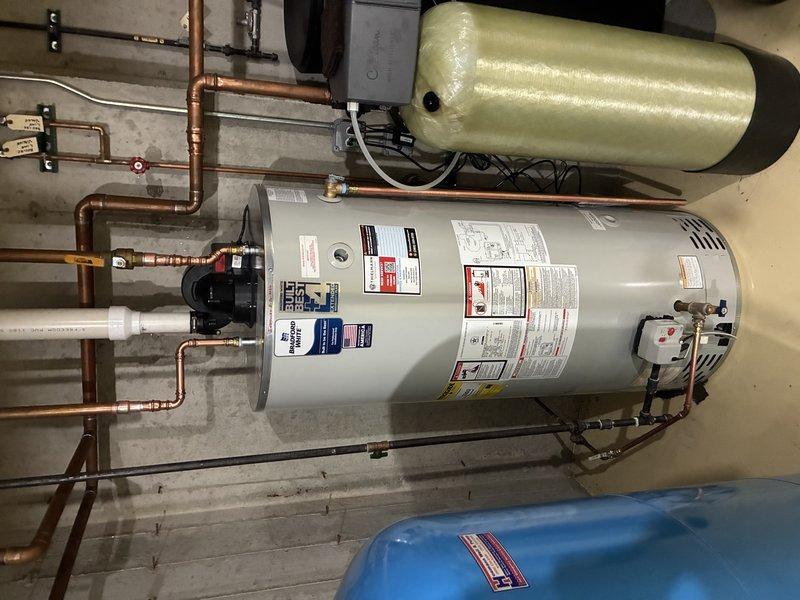 Installed 75-gallon residential water heater with complete copper piping connections, integrated circulation pump, and expansion tank. Customer declined permit acquisition for this installation, and no licensed electrician was utilized for electrical connections.