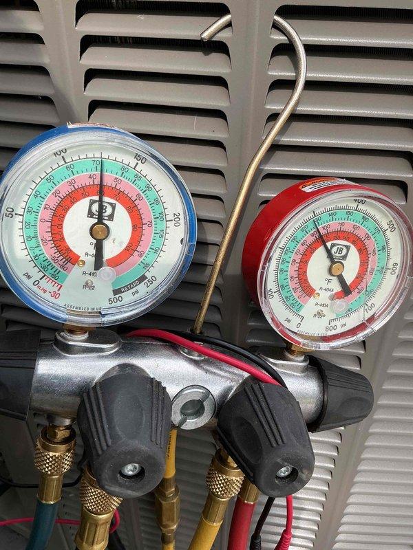 Completed comprehensive AC tune-up on outdoor condensing unit. Performed electrical inspection of contactor and dual-run capacitor, verified all wire connections secure, and used refrigerant manifold gauges to check system pressures and confirm proper R-410A refrigerant charge levels. Unit operating within manufacturer specifications with no deficiencies noted.