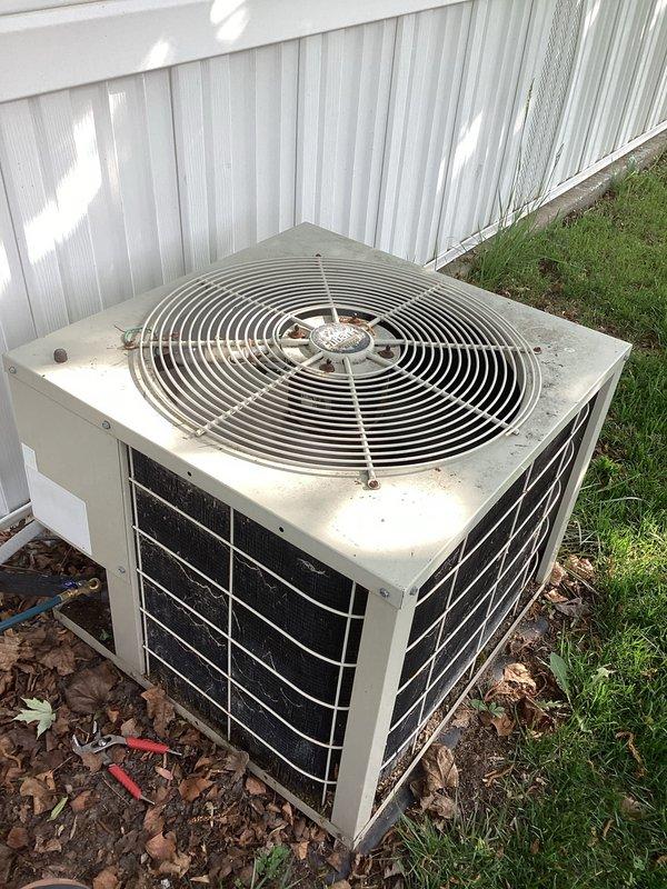 Responded to no cooling complaint on aging residential air conditioning system. Upon arrival, performed diagnostic inspection of outdoor condenser unit, which showed signs of age with dirt and debris accumulation on top surface and dusty mesh grille panels. Documented equipment condition with photographs for service records. Unit appeared operational but required thorough assessment to determine cause of cooling failure.