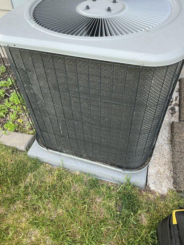 Completed annual air conditioning tune-up on outdoor condenser unit. Performed standard maintenance inspection, documented equipment information and condition with photographs, and verified unit operation. Protective mesh grille showed accumulation of dirt and debris consistent with normal outdoor exposure.