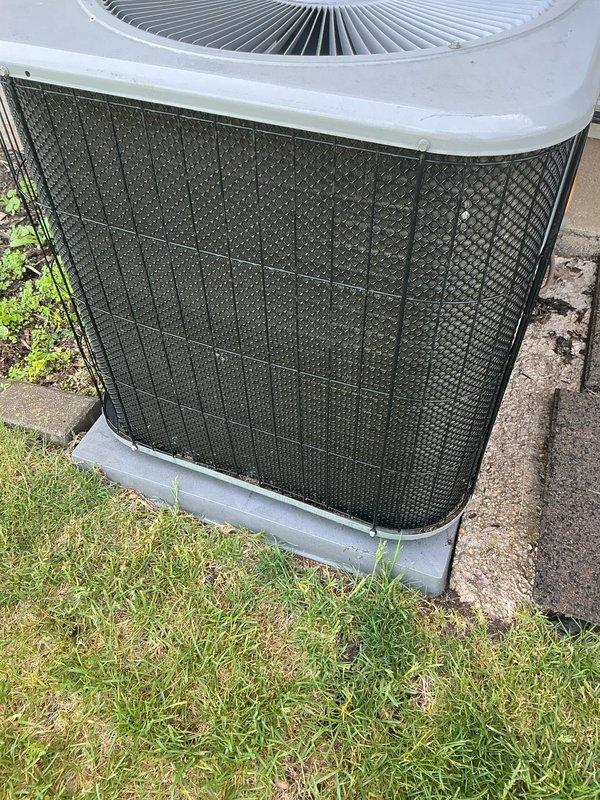 Completed annual air conditioning tune-up on outdoor condenser unit. Performed standard maintenance inspection, documented equipment information and condition with photographs, and verified unit operation. Protective mesh grille showed accumulation of dirt and debris consistent with normal outdoor exposure.