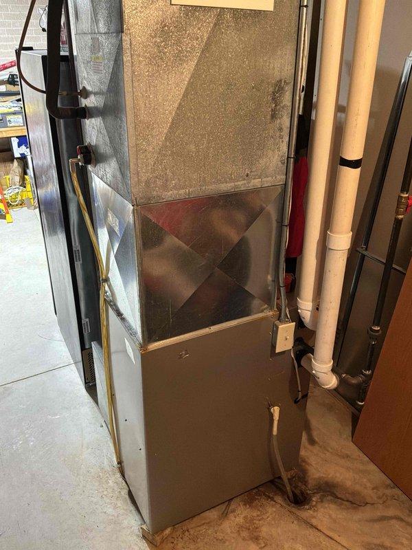 Conducted on-site estimate for complete air conditioning system replacement in single-story condominium unit. Evaluated existing furnace and HVAC equipment located in utility room, documenting current system configuration including ductwork, condensate drainage, and electrical connections. Photographed equipment showing age-related wear, discoloration on air handler components, and rust staining along ductwork seams, indicating potential moisture infiltration issues. Gathered necessary information to prepare replacement estimate for neighboring unit as well.