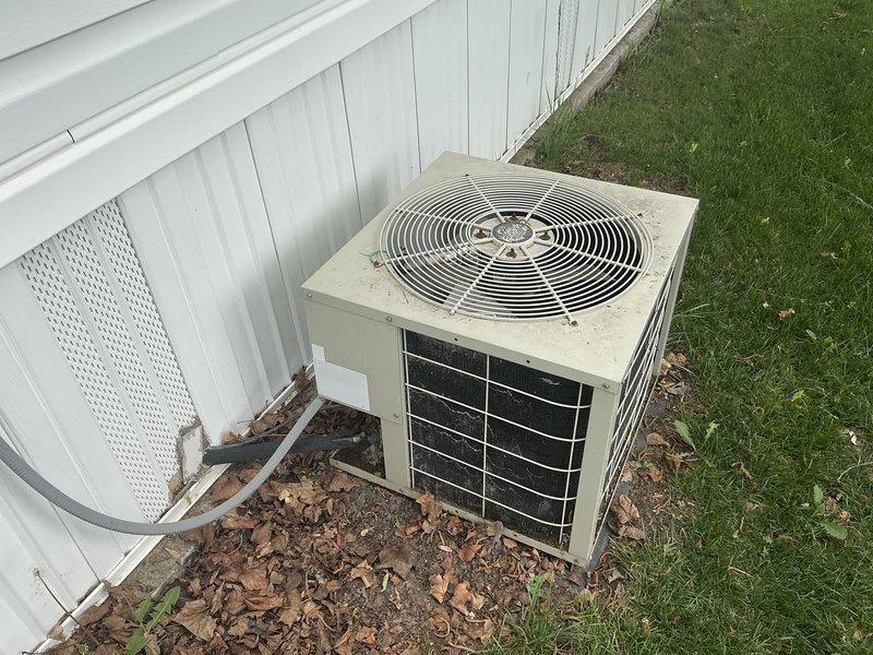 Conducted comprehensive site evaluation of existing outdoor AC condenser unit and indoor air handler system for replacement estimate. Documented current equipment condition, including aging outdoor unit with visible wear, refrigerant line configuration, and indoor mechanical cabinet containing condensate pump assembly with associated drainage components and electrical connections.