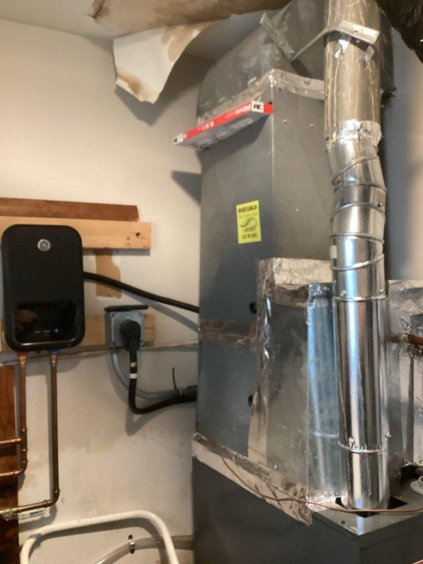 Completed comprehensive mechanical room inspection for new homeowner experiencing multiple system issues. Evaluated central air conditioning system, including air handler unit, refrigerant lines, and ductwork connections. Inspected furnace installation, mounting hardware, and electrical connections. Assessed water softener system and related plumbing components. 

Identified chimney connection requiring attention and provided recommendation for proper venting modifications to ensure safe operation of heating equipment. Documented existing HVAC equipment condition, noting standard installation configuration with metallic ductwork secured with proper strapping. Verified air handler mounting, drainage system components, and copper refrigerant line routing. Observed wall-mounted auxiliary equipment with copper piping connections in utility area.

Recommended chimney service to address venting concerns for optimal system performance and safety compliance.
