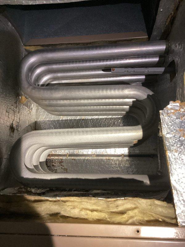 # HVAC Tune-Up Service Completed

Performed comprehensive tune-up on MagicPak combination heating and cooling unit. Inspection revealed ice buildup on internal bracket component and evaporator coil assembly showing signs of oxidation and discoloration. Completed standard maintenance protocol including visual inspection of heat exchanger coils, electrical connections, and control board wiring. Documented unit condition with photographic evidence showing serpentine coil configuration, insulation integrity, and overall system components for service records.