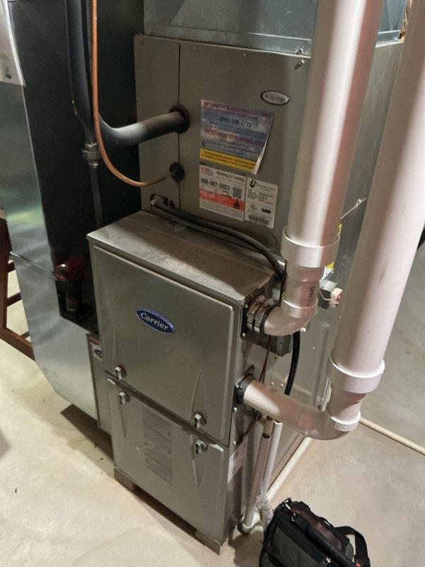 Completed comprehensive air conditioning tune-up service on residential Carrier HVAC system. Performed standard maintenance procedures including inspection of indoor furnace unit and outdoor condenser, verified proper operation of all components, checked refrigerant lines and connections, and documented system condition with photographs showing equipment in good working order with no immediate concerns identified.