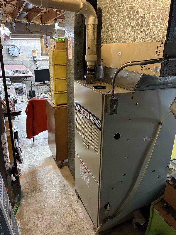 Provided comprehensive estimate for complete HVAC system replacement on aging 30+ year old air conditioning and heating equipment. Unit remains operational but has exceeded its expected service life, with previous contractor recommending full system replacement. Evaluated existing furnace/air handler installation in basement mechanical room, noting aged ductwork with visible deterioration and discoloration. Documented current system configuration including metal furnace unit with overhead supply ductwork and assessed accessibility for replacement equipment installation.