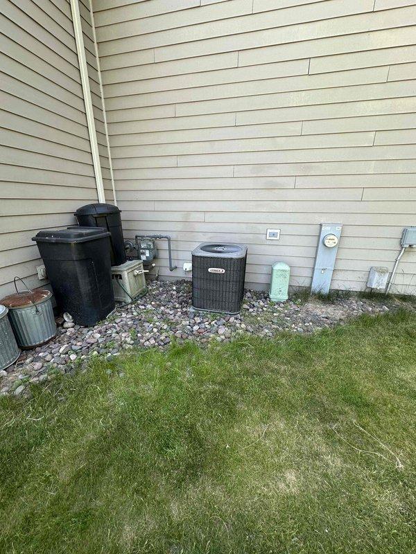 Provided estimate for complete HVAC system replacement including air conditioning unit and natural gas furnace located in basement. Upon inspection, discovered rodent damage to electrical wiring rendering the AC unit inoperable. Documented existing outdoor condenser unit with protective mesh cage and indoor furnace equipment for replacement specifications.