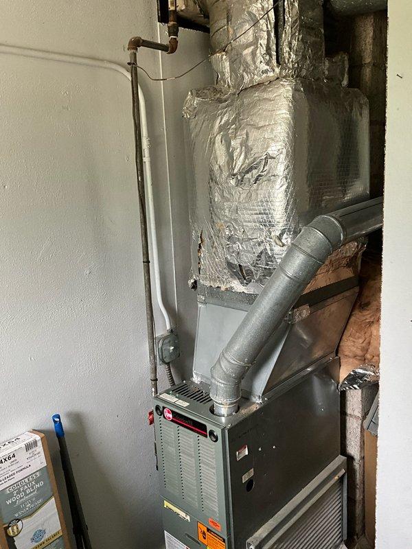 Conducted comprehensive estimate for complete HVAC system replacement in residential property. Evaluated existing chimney-vented furnace in mechanical room and assessed requirements for upgrading to high-efficiency cold-climate heat pump system. Inspected current air conditioning system and identified lack of ductwork to second floor, requiring design considerations for whole-home cooling solution including upper level. Assessed existing water heater installation and specified requirements for high-capacity heat pump water heater to accommodate six-person household demand. Documented existing mechanical room layout, ductwork configuration, copper plumbing lines, and utility connections through detailed photography. Reviewed space constraints and ventilation requirements for proposed equipment upgrades, noting transition from atmospheric chimney venting to direct-vent or condensing technology for improved efficiency and safety compliance.