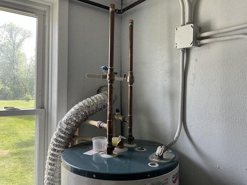 Conducted comprehensive estimate for complete HVAC system replacement in residential property. Evaluated existing chimney-vented furnace in mechanical room and assessed requirements for upgrading to high-efficiency cold-climate heat pump system. Inspected current air conditioning system and identified lack of ductwork to second floor, requiring design considerations for whole-home cooling solution including upper level. Assessed existing water heater installation and specified requirements for high-capacity heat pump water heater to accommodate six-person household demand. Documented existing mechanical room layout, ductwork configuration, copper plumbing lines, and utility connections through detailed photography. Reviewed space constraints and ventilation requirements for proposed equipment upgrades, noting transition from atmospheric chimney venting to direct-vent or condensing technology for improved efficiency and safety compliance.