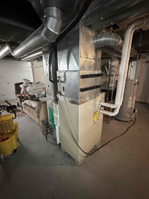 Conducted comprehensive site assessment for complete HVAC system replacement in residential basement location. Evaluated existing furnace unit with deteriorated components and outdoor air conditioning condenser positioned on concrete pad against exterior wall. Documented current equipment specifications, ductwork configuration, and installation parameters including PVC condensate drainage and electrical connections. Provided detailed replacement estimate for new furnace and AC system, accounting for existing infrastructure modifications and proper sizing requirements based on home heating and cooling load calculations.
