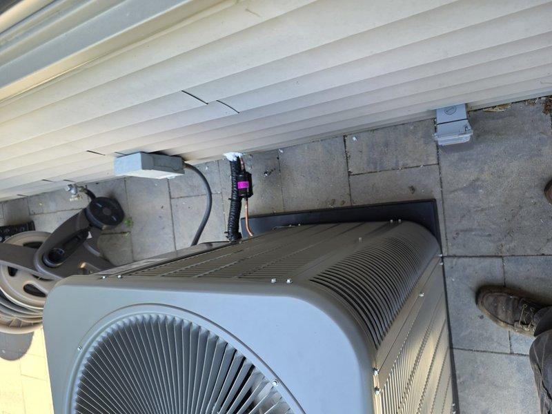 # HVAC Installation Summary

Completed full air conditioning system installation including outdoor condensing unit and indoor evaporator coil. Installation performed in accordance with permit requirements and coordinated with licensed electrician for proper electrical connections.

# Work Performed

Installed new outdoor condensing unit on prepared concrete paver pad against exterior wall. Unit positioned for optimal airflow and serviceability with proper clearances maintained. Secured electrical conduit and wiring to concrete block wall using appropriate mounting brackets. Connected electrical power supply in coordination with licensed electrician to ensure code-compliant installation.

Inside mechanical room, installed new air handler with evaporator coil assembly. Mounted unit vertically on interior wall with proper support and leveling. Installed refrigerant line set connecting outdoor condensing unit to indoor coil, routing copper lines through wall penetration. Brazed all refrige