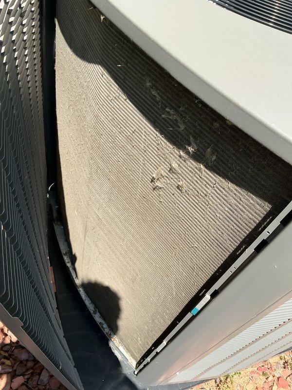 Completed preventative maintenance tune-up on residential air conditioning system. Inspected outdoor condensing unit, noting moderate dust and debris accumulation on condenser coil fins that could impact heat transfer efficiency. Documented current condition of unit components including coil surfaces, cabinet housing, and protective grilles for maintenance records.
