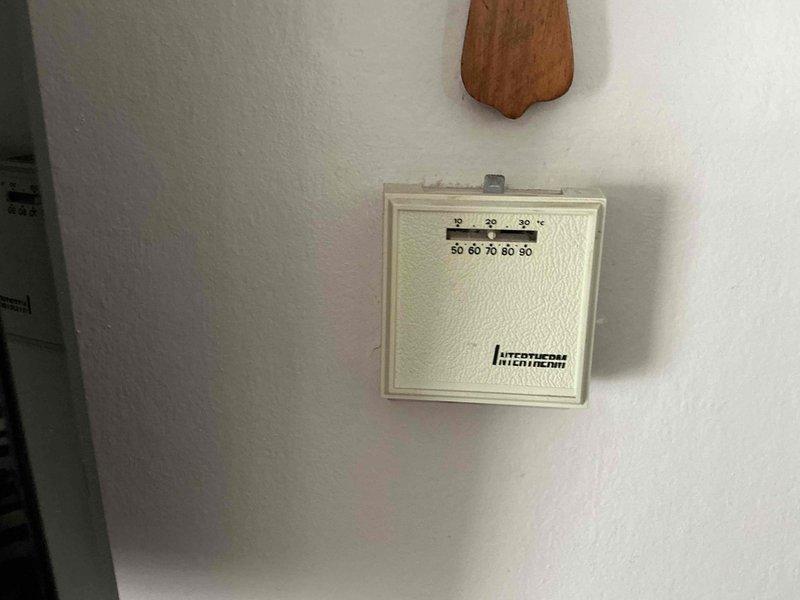 Completed HVAC system replacement estimate for mobile home unit. Assessed existing mechanical thermostat and exterior equipment location, documented current system configuration including wall-mounted analog temperature control and outdoor unit placement. Provided comprehensive replacement options and recommendations for new air conditioning system installation.