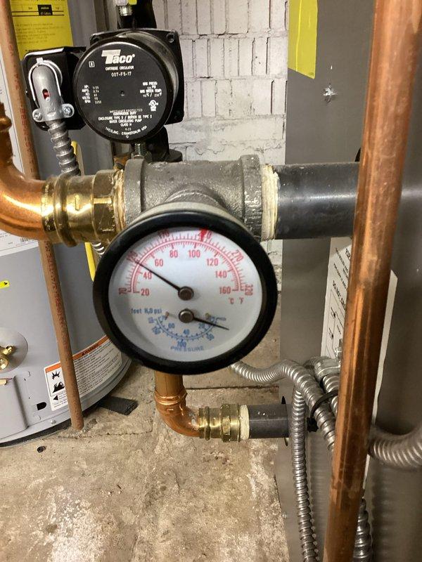 Responded to pre-sale inspection failure requiring correction of backflow preventer installation. Upon arrival, identified ASSE 1012 backflow prevention device with improper vent port configuration lacking required air gap. The vent port had a direct pipe connection, which violates code requirements for atmospheric discharge protection.

Corrected the installation by removing the direct pipe connection from the vent port fitting and establishing a proper air gap to allow atmospheric venting as mandated by ASSE 1012 standards. Verified that the backflow preventer assembly, integrated with the hydronic heating system's circulation pump and pressure monitoring equipment, now meets code compliance for the final inspection. The Taco circulator pump and associated copper piping network remained fully operational throughout the service call. System pressure verified within normal operating parameters following correction.