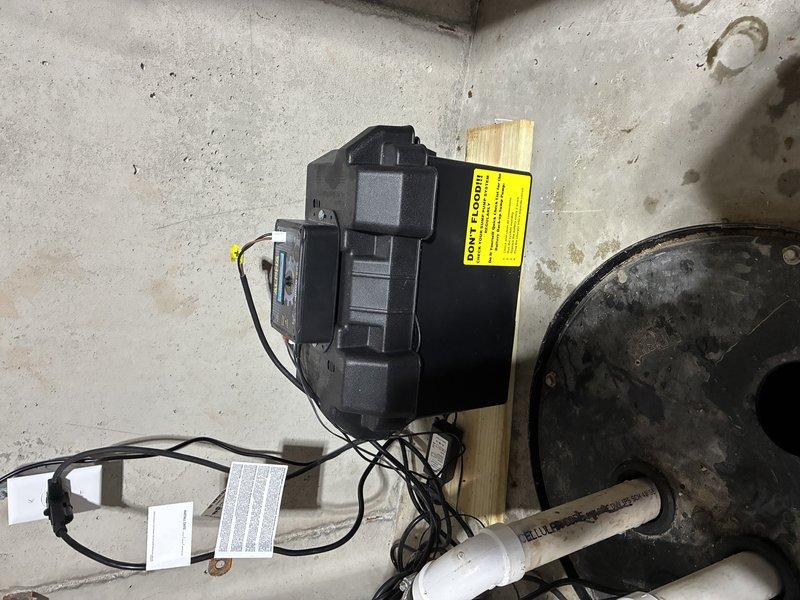 Completed installation of JMI sump pump system in basement utility area. Positioned and secured sump pump basin on concrete floor with proper leveling and stabilization. Mounted pump motor unit with electrical components and connected discharge piping using white PVC with appropriate fittings and secure fastening. Routed electrical wiring from pump motor to power source with proper wire management and safety labeling. Tested system operation to verify proper pump activation, discharge flow, and automatic shut-off functionality upon completion.