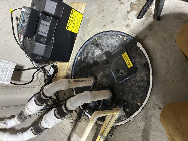 Completed installation of JMI sump pump system in basement utility area. Positioned and secured sump pump basin on concrete floor with proper leveling and stabilization. Mounted pump motor unit with electrical components and connected discharge piping using white PVC with appropriate fittings and secure fastening. Routed electrical wiring from pump motor to power source with proper wire management and safety labeling. Tested system operation to verify proper pump activation, discharge flow, and automatic shut-off functionality upon completion.