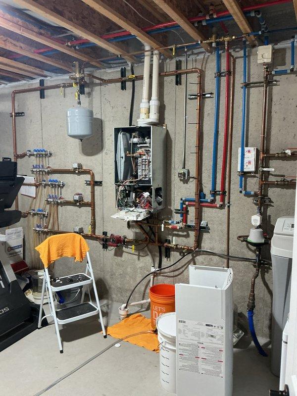 Assessed non-functional tankless water heater in basement mechanical room and provided replacement estimate. Unit was determined to be inoperable and requiring full replacement. Evaluated existing hydronic heating system integration, including multiple zone controls with manifold assembly, circulation pump, expansion tank, and extensive copper and PEX piping network to ensure compatibility with new tankless installation.