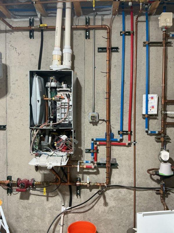 Assessed non-functional tankless water heater in basement mechanical room and provided replacement estimate. Unit was determined to be inoperable and requiring full replacement. Evaluated existing hydronic heating system integration, including multiple zone controls with manifold assembly, circulation pump, expansion tank, and extensive copper and PEX piping network to ensure compatibility with new tankless installation.