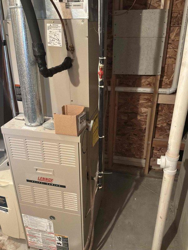 Completed on-site assessment for replacement estimate of existing natural gas furnace and air conditioning system, both operational but over 20 years old. Documented current Lennox furnace installation in basement utility area with associated ductwork, electrical panel configuration, and surrounding HVAC infrastructure including water heater proximity and available workspace for equipment replacement.